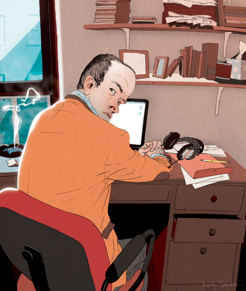 Portrait of Leo Richter seated at a desk with papers, books, and a laptop.